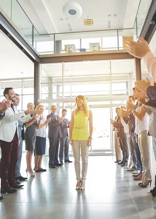Team applauding blonde female coworker on her lead generation performance.